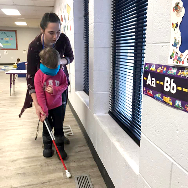 Miss Brittany showing how to use blind guide cane